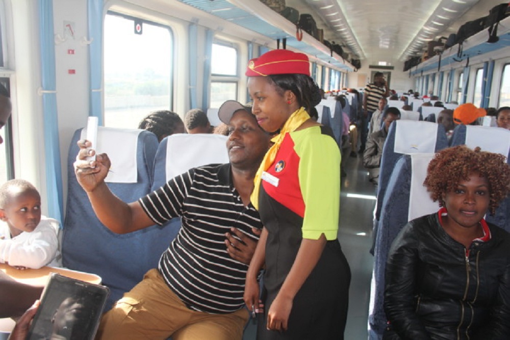 A passenger takes a selfie with an attendant on the Madaraka Express in a picture taken before the Covid-19 pandemic. Kenya Railways has introduced a night service between Nairobi and Mombasa.