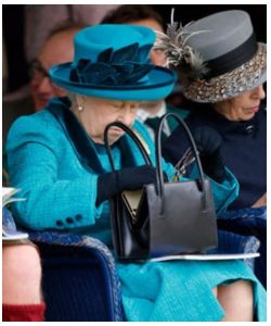Queen Elizabeth looking inside her handbag
