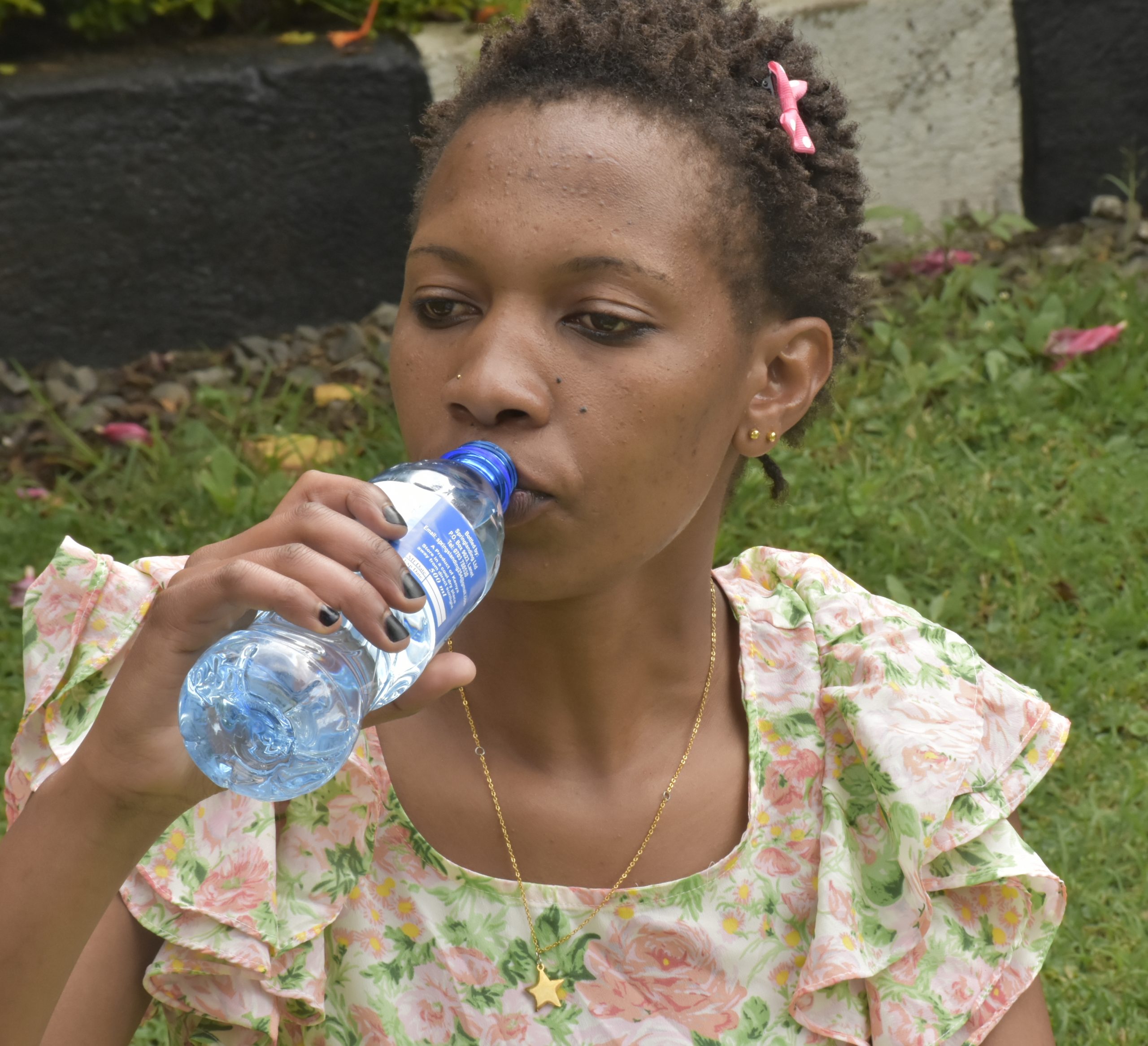A young woman drinking bottled water www.bisinesstoday.co.ke