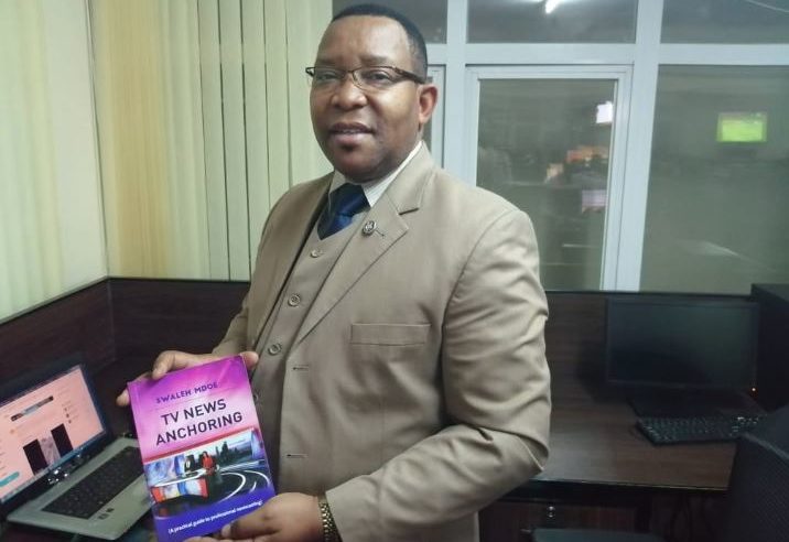 Swaleh Mdoe displays a copy of his book www.businesstoday.co.ke