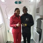 World marathon record holder Eliud Kipchoge poses for a photo with a KQ air hostess after landing in the country. Photo/ Kenya Airways