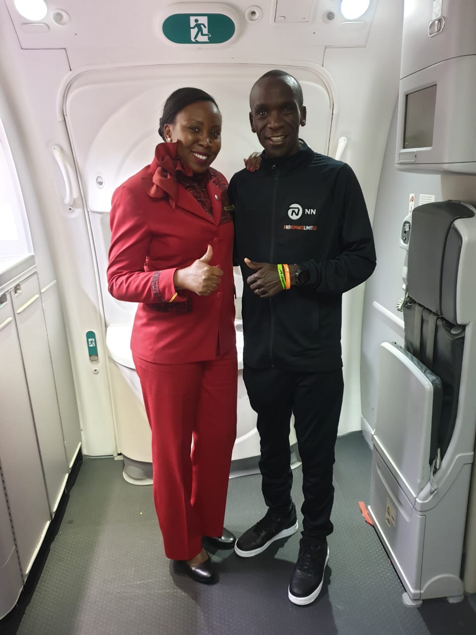 World marathon record holder Eliud Kipchoge poses for a photo with a KQ air hostess after landing in the country. Photo/ Kenya Airways