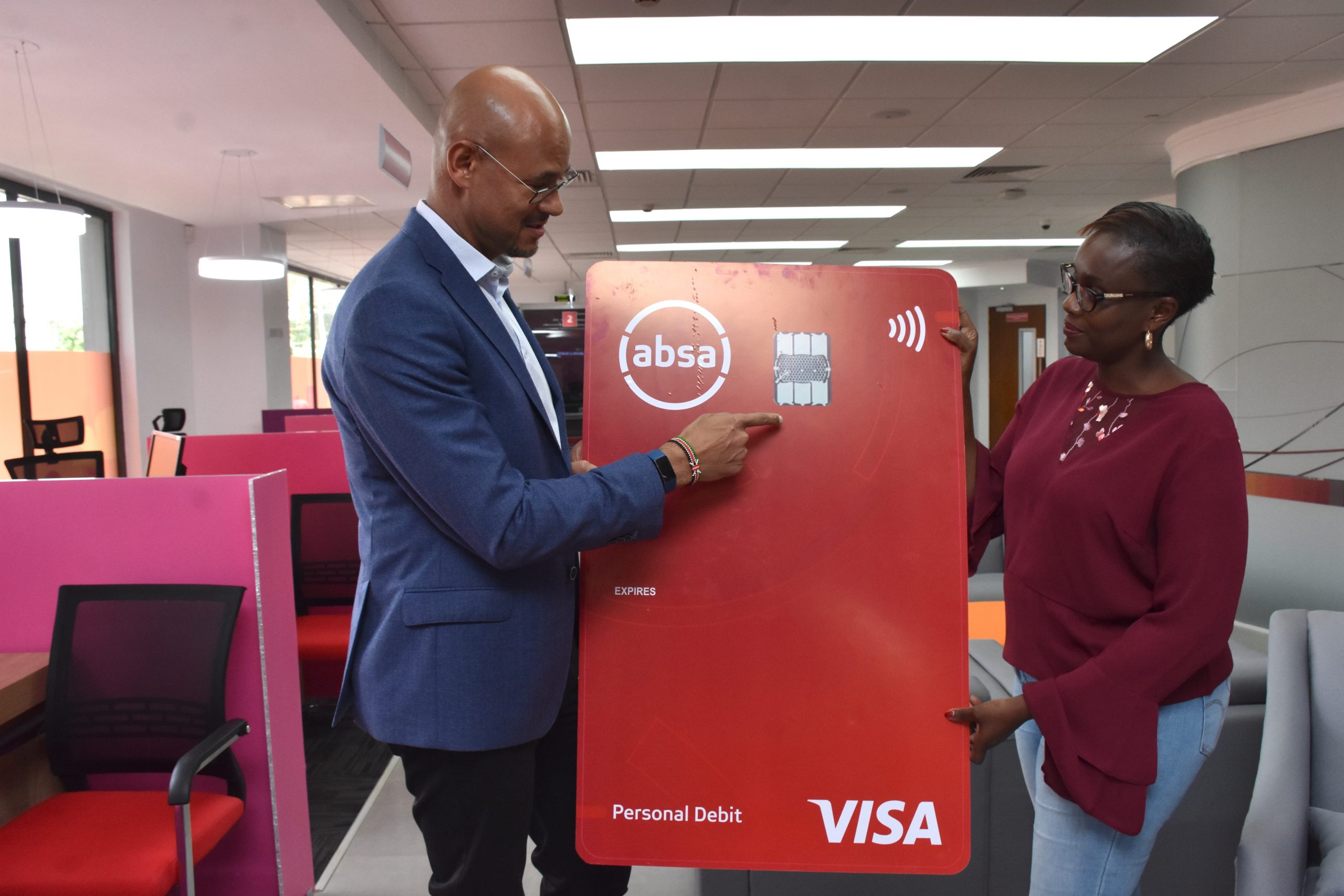 Jeremy Awori, Managing Director of Barclays Kenya, soon to be Absa, explains features of the new vertical Absa credit and debit cards to Sheila Momanyi, Manager Sarit Centre branch. www.businesstoday.co.ke
