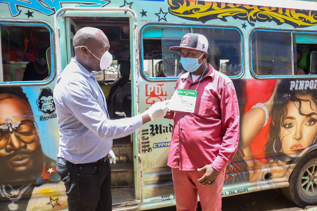 Boniface Mungania(left)Head of M-PESA product Management at Safaricom PLC explains to Simon Maina conductor at Forward Traveler Sacco, how his passengers should pay fare with M-PESA during an awareness campaign.