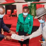 President Uhuru Kenyatta hands over a title deed to a member of the Samburu community on November 4, 2020 as Lands Cabinet Secretary Farida Karoney looks on during a ceremony in Nairobi.