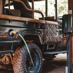 A Land Cruiser tour van converted to an electric vehicle by Optibus pictured charging.