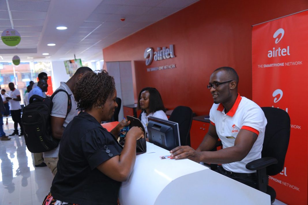 Airtel representatives serve customers at a store. Airtel Kenya will be required to comply with local ownership regulations by 2024.