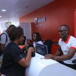 Airtel representatives serve customers at a store. Airtel Kenya will be required to comply with local ownership regulations by 2024.