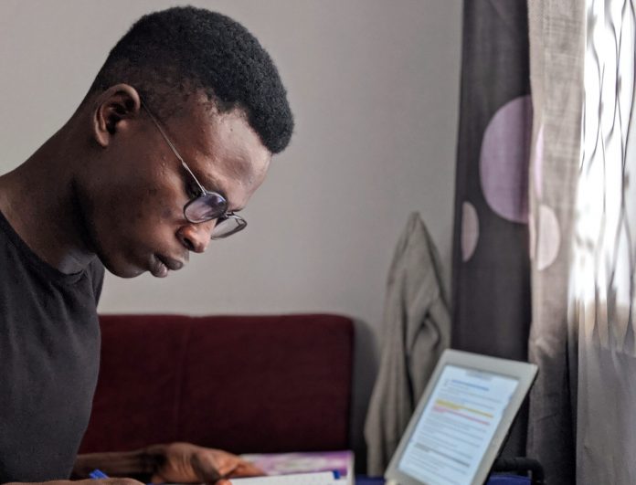 A young man studying Globally, there will be massive changes in the next 10-15 years, highly driven by technology and will bring more connectedness and opportunities. The youth need to keep abreast of these changes for them to remain relevant and foster personal growth.