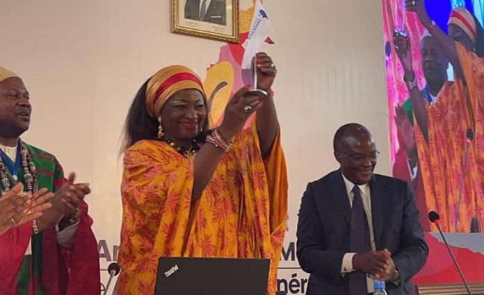 From left - Cameroon’s Minister of Housing and Urban Development Hon. Célestine Ketcha Courtès (centre) raises Shelter Afrique flag as she assumes the chairmanship of Shelter Annual General Meeting (AGM) Bureau at the Company’s 40 AGM held in Yaoundé, Cameroon, flanked by Shelter Afrique Chief Executive Officer Andrew Chimphondah (left) Kenya’s Transport, Infrastructure and Housing Cabinet Secretary James Macharia - who is the immediate former Chairman of Shelter Afrique AGM.