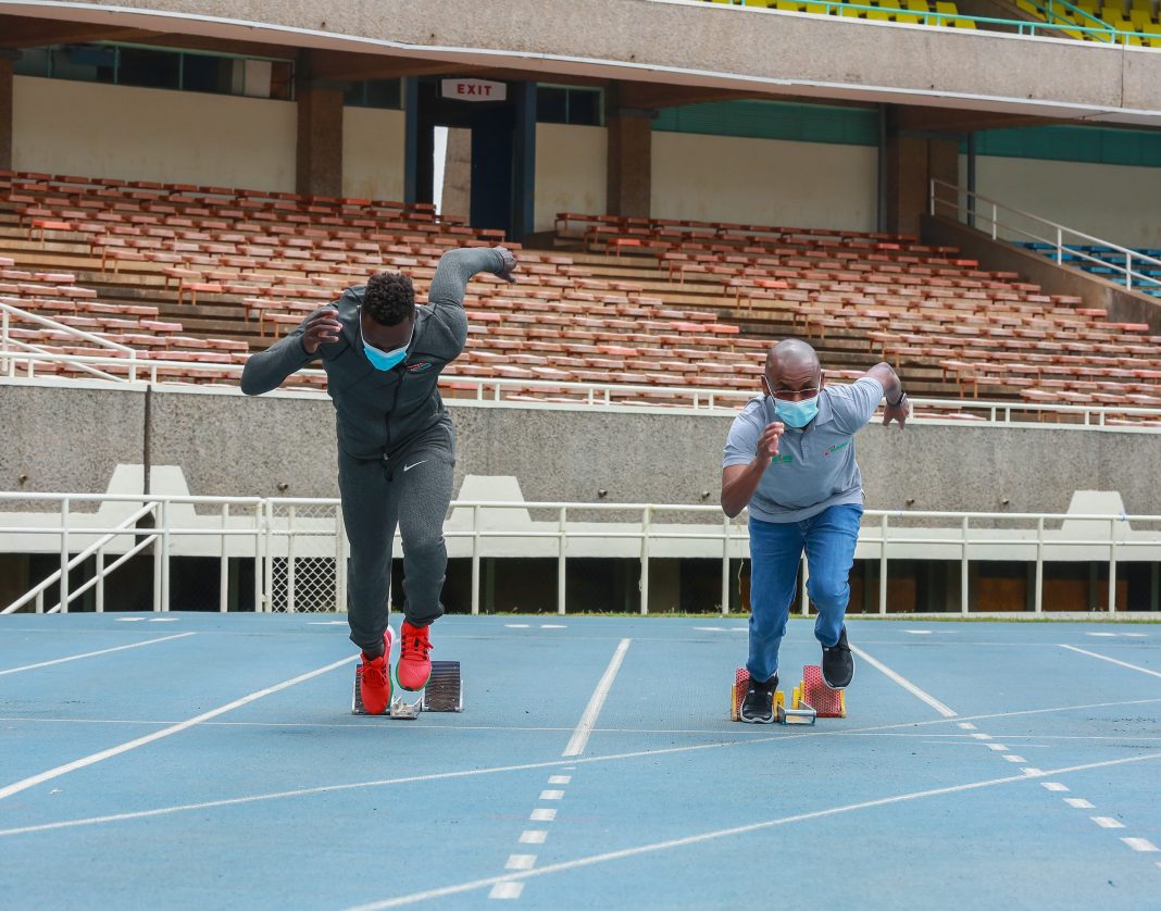 Mark Otieno sprints with Safaricom CEO Peter Ndegwa after the telco unveiled a sponsorship for the Tokyo Olympics-bound athlete in Nairobi, Kenya on July 13, 2021.