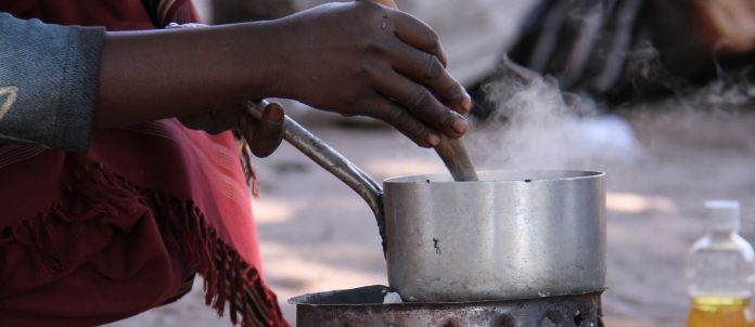 A woman cooking outside. The VAT exemption is also expected to help companies boost their sales and production of clean cooking products. [Photo/ Clean Cooking Alliance]