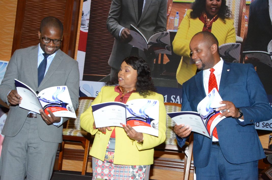 Serianu Chief Executive Officer (left), Dr. Catherine Ngahu Executive Chairman SBO Research and Serianu Chief Operating Officer Joseph Mathenge peruse the newly released 2020/ 2021 Sacco Technology Report.