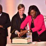 Treasury CAS Eric Wafukho (L) looks on as DIB Bank Kenya Board of Director Alison Blignault (C) and KNCCI Vice Chair Women in Business Nancy Muthoni cut a cake to mark the bank's 4 years Anniversary