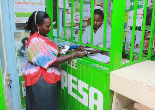 A customer at an M-Pesa agent outlet. In 2007, Safaricom and Vodafone launched M-PESA in Kenya as a way for customers to instantly send money to each other. [Photo/ Kuza Biashara]
