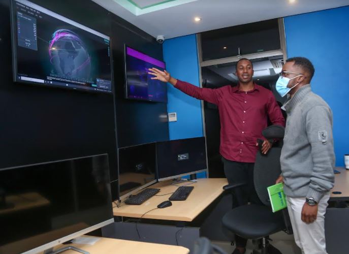 Dimension Data East and West Head of Managed Security Services Dr. Bright Mawudor (left) shows a journalist how the company monitors cyber security threats for businesses at their Threat Intelligence Centre during a media briefing at the firm’s offices in Nairobi.