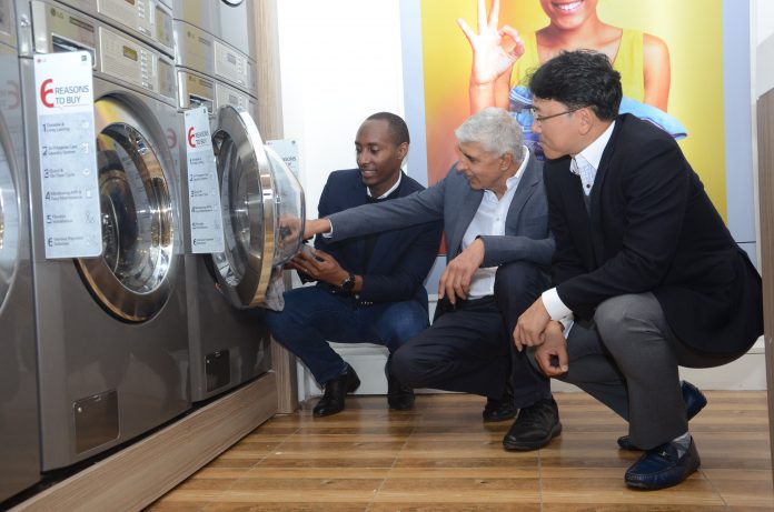 (L-R) Brian Gacheru CEO Pristine Linen & Laundry Ltd, Shailesh Kanani MD Hotpoint Appliances Ltd and LG East Africa Home Appliances Product Manager Mr. Eden Seo during the launch of a new smart laundry shop at the Thika Road Mall (TRM) in Nairobi. LG will partner with vendors and local entrepreneurs to roll out commercial machine reference stores as it seeks to tap into the fast-growing on-demand laundry market in East Africa.