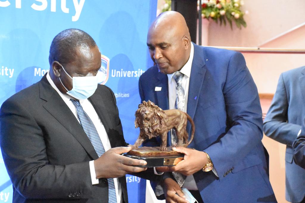 MKU founder Prof. Simon Gicharu (r) gifts Interior Cabinet Secretary Fred Matiang'i during the opening of the Mwai Kibaki Convention Centre on November 4, 2021. [Photo/ Courtesy]