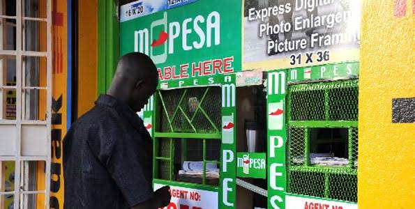 A customer at a Safaricom M-Pesa agent outlet. Safaricom's Fuliza overdraft service launched in 2019 has proved wildly successful for the firm's bottomline even as citizens and policy-makers raise concerns. [Photo/ Courtesy]