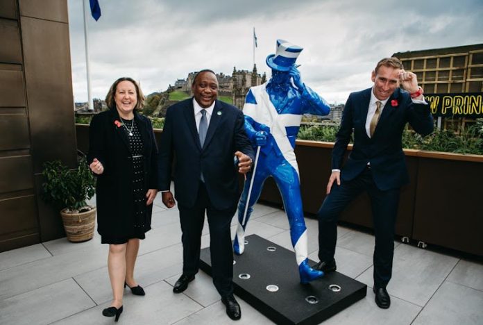 President Uhuru Kenyatta poses with a life-size Johnnie Walker statue in Edinburgh, Scotland flanked by UK State Secretary for International Trade Anne-Marie Trevelyan and Diageo's Global Supply Chain & Procurement and Chief Sustainability Officer Ewan Andrew.