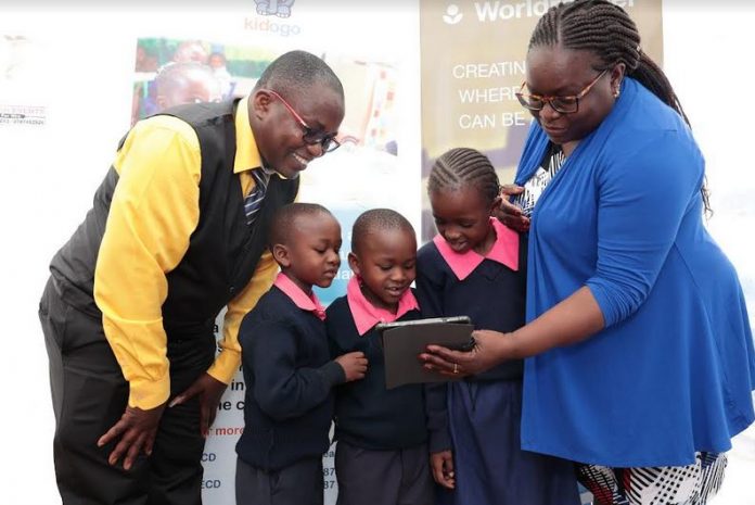 Joan Mwachi-Amolo, Regional Director at Worldreader and Walter Olando, Director of Bethany Joy School in Kawangware introducing pupils to the digital learning application during the launch of a survey on the successof digital reading in schools and communities.