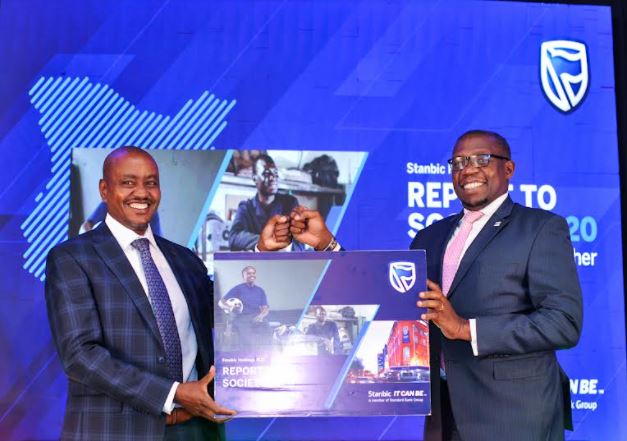 Stanbic Bank Kenya Head of Risk and Chair of SEE Agenda, Edwin Mucai (left), and CEO, Nairobi Securities Exchange (NSE), Geoffrey Odundo (right) hold the dummy Report to Society 2020