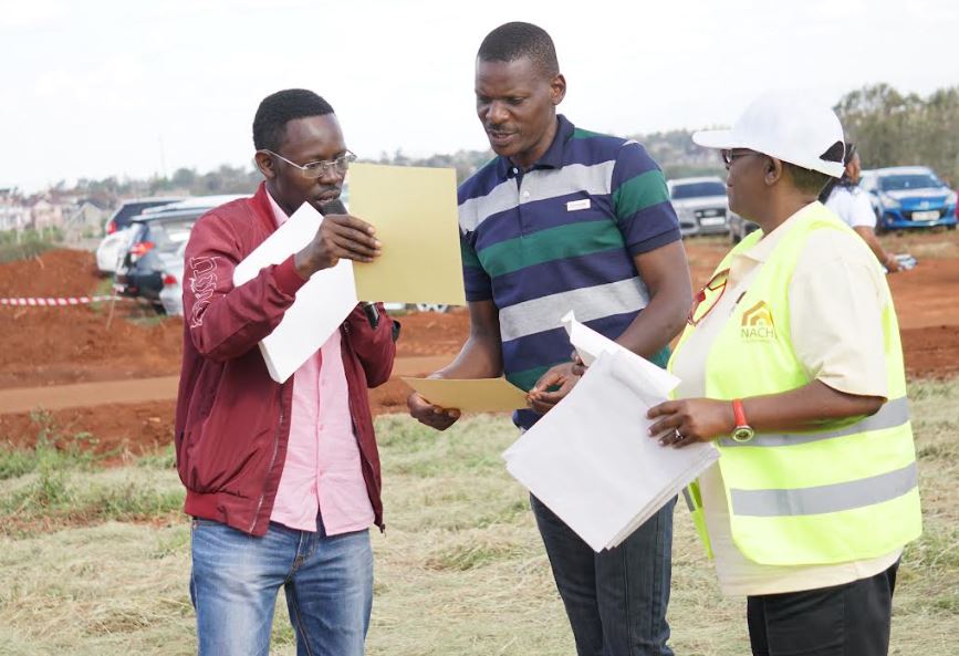 Finsco Africa Chief Executive Officer John Mwaura hands over a certificate to Michael Orucho Ngala (Centre) after he purchased a plot from NACHU at RiverLine Ridges Open Day.