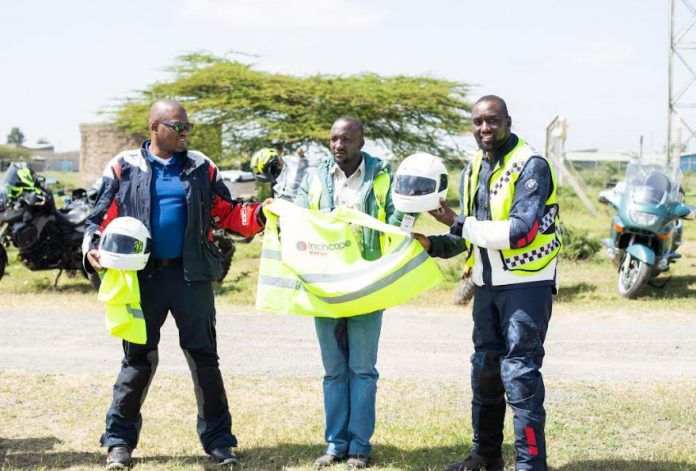 Inchcape Managing Director, Hussein Ibrahim (R) and Jimmi Kabugi (L), a BMW bike rider hand over safety gear to Amos Turere, Chairman Birika Boda Boda Association
