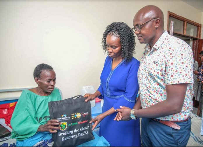 Fistula From Right: M-PESA Foundation Representative, Onesmus Mulu, the First Lady of Tharaka-Nithi county Mrs. Margaret Njuki, hand over a gift hamper at one of the fistula surgery beneficiary Juliet Ciantuni.