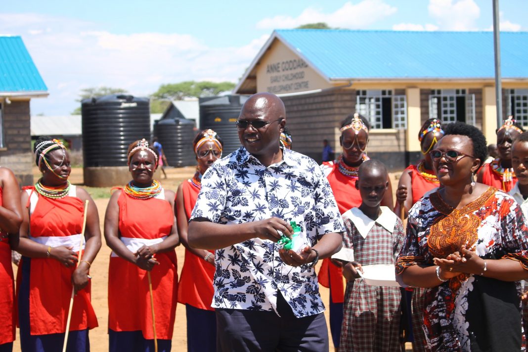 Labour Cabinet Secretary Simon Chelugui speaks at Salabani Primary School during the commissioning of new classes and other structures constructed by ChildFund Kenya at the cost of Ksh30 million. Looking on is ChildFund Kenya Country Director Alice Anukur (right).