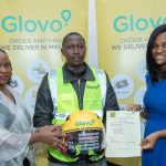 Glovo Kenya General Manager Caroline Mutuku (left) hands over an helmet to Dennis Mutinda, a Glovo rider during the couriers pledge launch. Looking on is Tokunbo Ibrahim, Glovo's Head of Government Relations SAA.