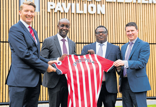 SportPesa CEO Ronald Karauri (second left) and SportPesa chairman Paul Ndung’u (second right) in Southampton on July 27, 2016 when they unveiled a partnership with Southampton FC. Between 2014 and 2018, the firm’s cumulative revenues stood at Ksh228.4 billion. [Photo/ Sportpesa]