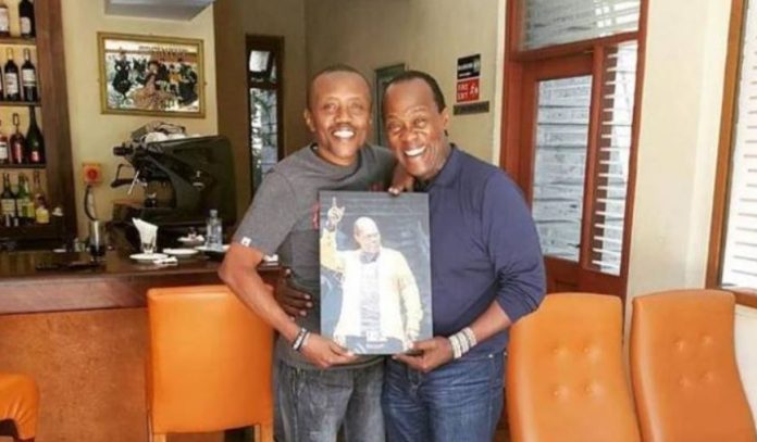 Jeff Joinange (R) pictured with Classic FM presenter Maina Kageni, holding a painting. [Photo/ KDRTV]