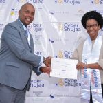 Joseph Mathenge, Serianu Chief Operating Officer (left) presents a Security Analyst Completion Certificate to Brenda Kamangara (right) during the Cyber Shujaa Second Cohort Graduation.