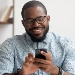 A mobile phone user. Charges on transfers between bank accounts and mobile money wallets returned at the turn of the year. Photo/ Pinkvilla]