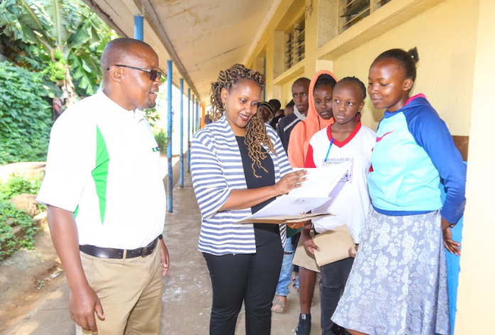 From Left: Stephen Matee, KCB Foundation Programme Manager and Rosalind Gichuru, KCB Group Director Marketing, Communications & Citizenship review Latifah Achieng’s (right) scholarship application papers at Moi Avenue Primary School in Nairobi. Latifah who scored 404 marks in her KCPE, studied at Harambee Primary school - BuruBuru is among the 10,000 students that applied for the KCB Scholarship programme that supports 1,000 students annually.