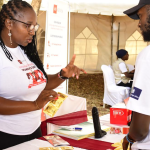 Attendees in the IWD event in Kibra Nairobi interacting with AHF IEC materials on HIV prevention