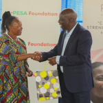 M-Pesa Foundation Trustee, John M Ohaga receiving a gift from ROSE beneficiary, Margaret Muriuki after the official launch of Micro-Enterprise accelerator program in partnership with M-Pesa and ROSE foundation at Dagoretti.