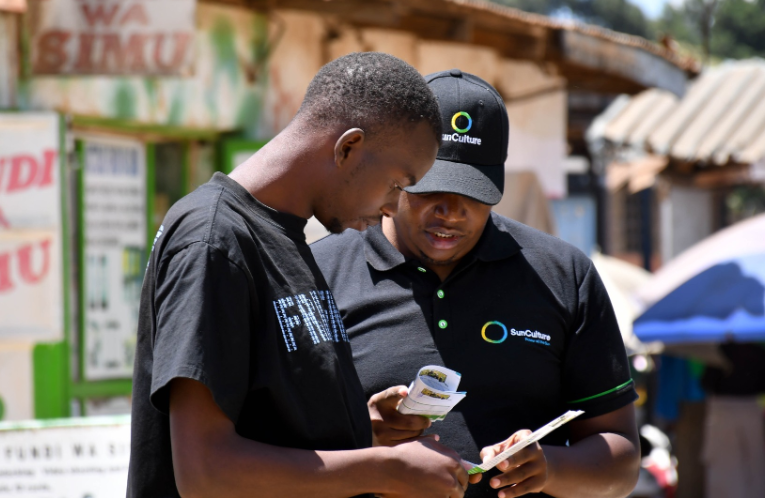 SunCulture Marketing Manager Brian Thuo speaks to a Nakuru resident.