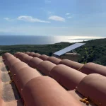 A Starlink receiver sits atop a house.