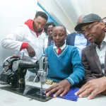 Safaricom CEO Dr. Peter Ndegwa (Right), Catherine Wangari, a student at Mumbi Primary School and Wangui Mwangi (left), a teacher at the school, at the Home Science laboratory during the handover of learning facilities by M-Pesa Foundation.