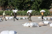 Locals carry rice from the Mwea Rice Growers Multipurpose Co-operative Society after the government confirmed it had paid up for all locally produced rice.