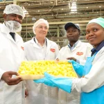 From left, Invest Kenya CEO John Mwendwa, PS Investments, Abubakar Hassan Abubakar, Delmonte MD, Wayne Cook and IQF Manager, Japheth Maingi look on as Annastacia Wavinya explain the pineapple canning process at the Delmonte Canning line