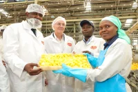 From left, Invest Kenya CEO John Mwendwa, PS Investments, Abubakar Hassan Abubakar, Delmonte MD, Wayne Cook and IQF Manager, Japheth Maingi look on as Annastacia Wavinya explain the pineapple canning process at the Delmonte Canning line