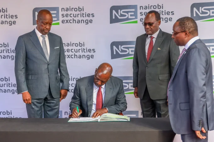 President William Ruto signs visitors book, seen by NSE Chairman Kiprono Kittony(l) Dr Chris Kipto PS Treasury and a top NSE official