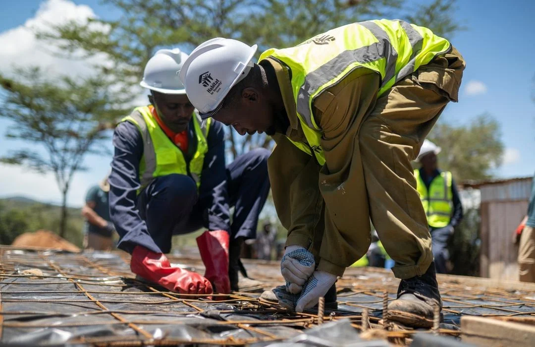 Habitat for Humanity Kenya team collaborating with community members and global volunteers during a house construction in Naibor Village, Laikipia