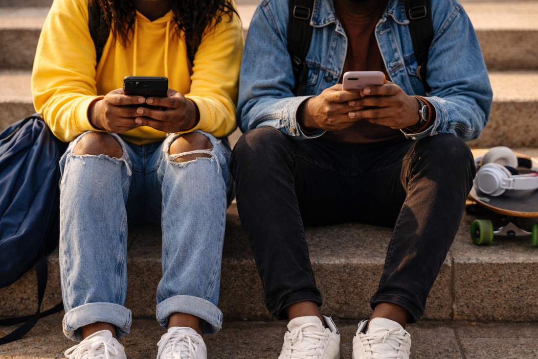 Teenagers with smartphones on concrete steps