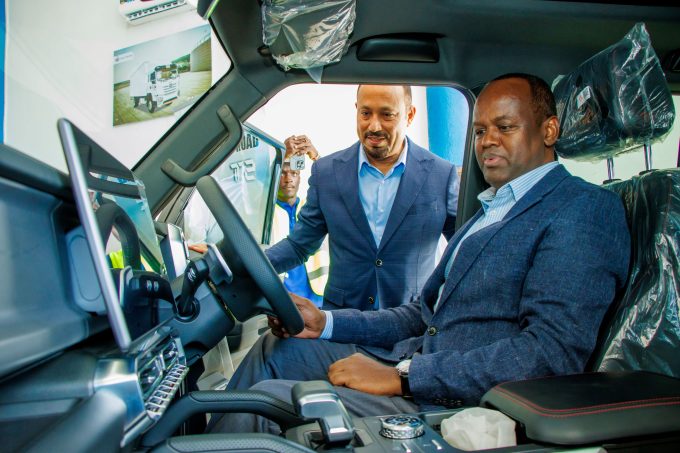 Absa Bank Kenya CEO Abdi Mohamed (Right) operates a truck during the signing of a memorandum of understanding for a strategic partnership with Transafrica Motors to support businesses in scaling their transport, logistics, and mobility operations. Looking on is Transafrica Motors Managing Director Ali Zubedi.