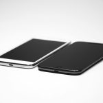 Two smartphones, one black and one white, placed on a white surface