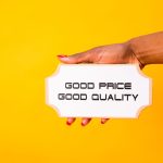 A hand holding a sign with 'Good Price Good Quality' against a vibrant yellow background.